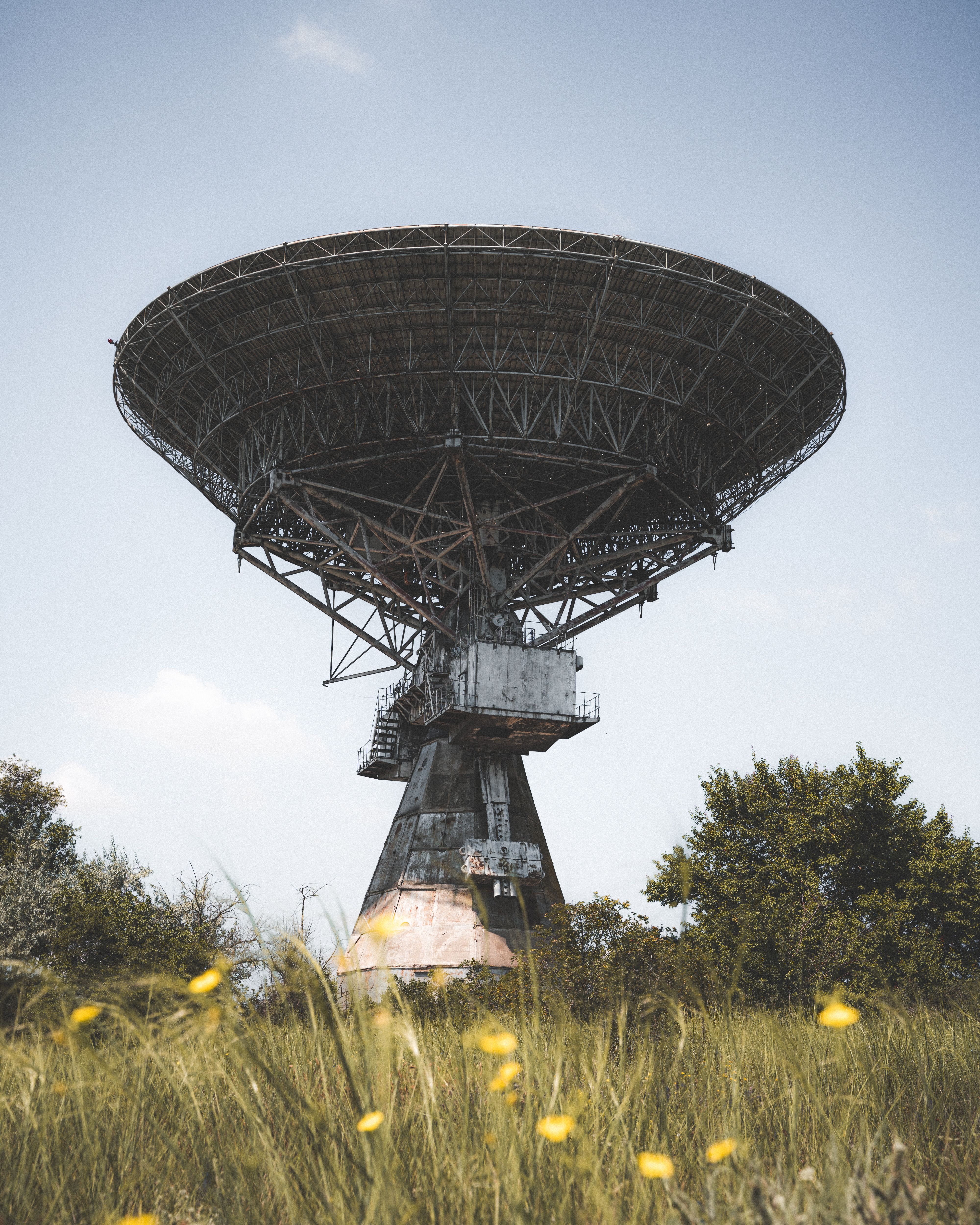 Large satellite ground-station dish under a clear sky.